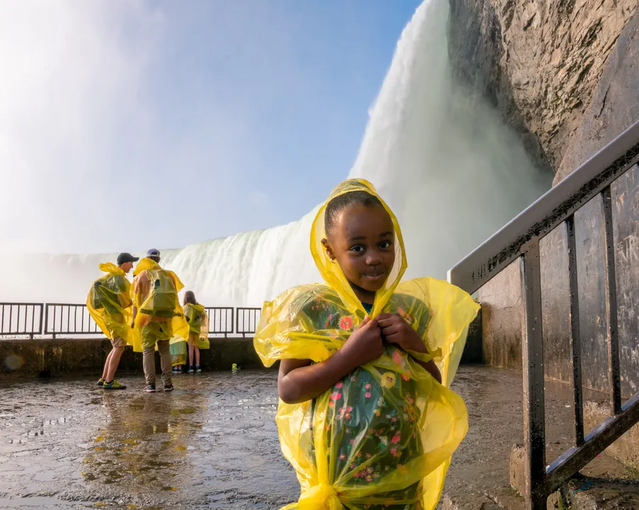 Child in yellow poncho enjoying Journey Behind the Falls experience