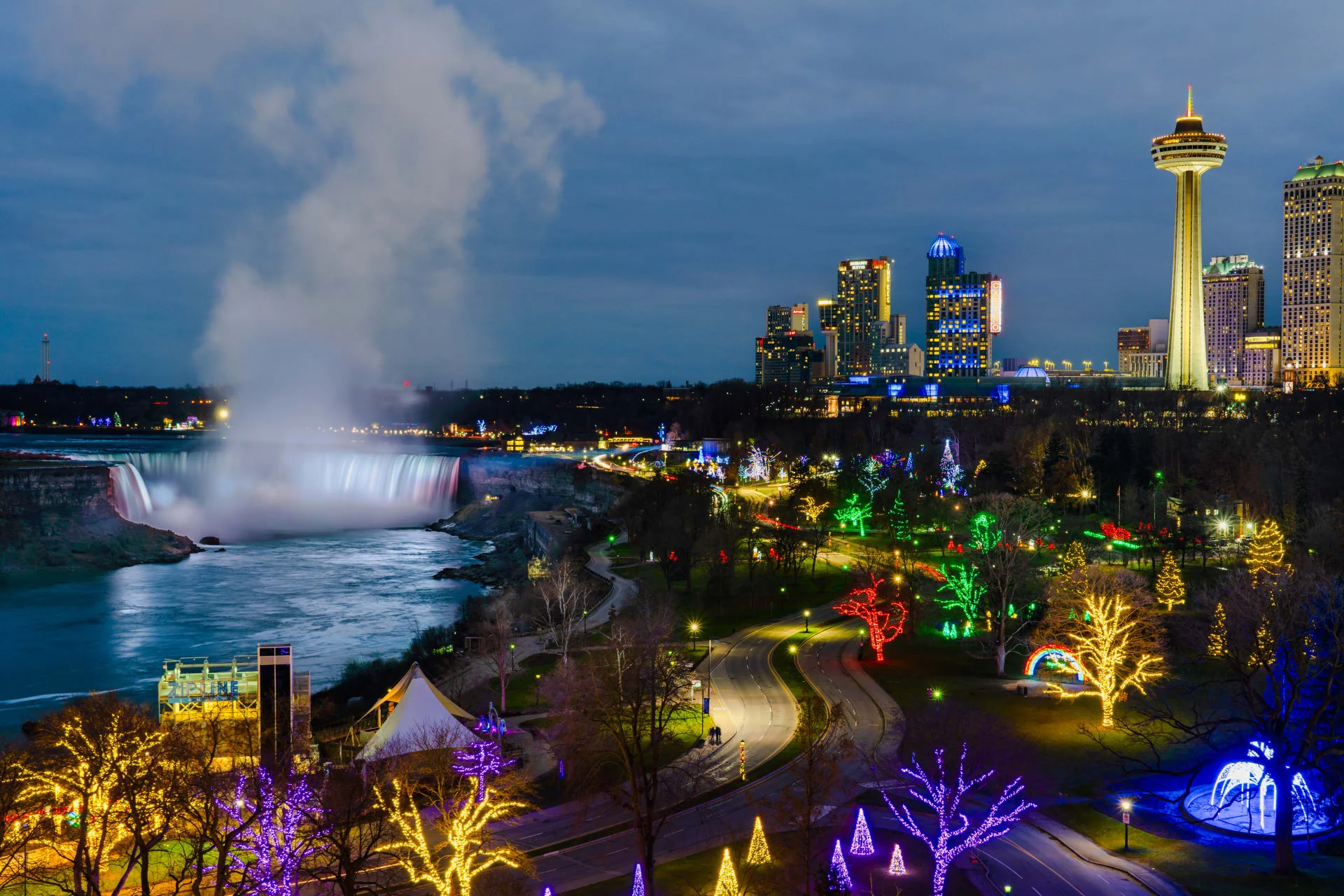 Breathtaking wide view of Niagara Falls skyline illuminated with colorful lights during winter festival