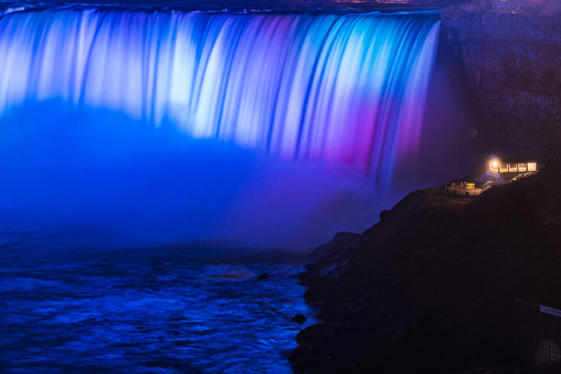 Journey Behind the Falls attraction illuminated in purple during Niagara winter festival
