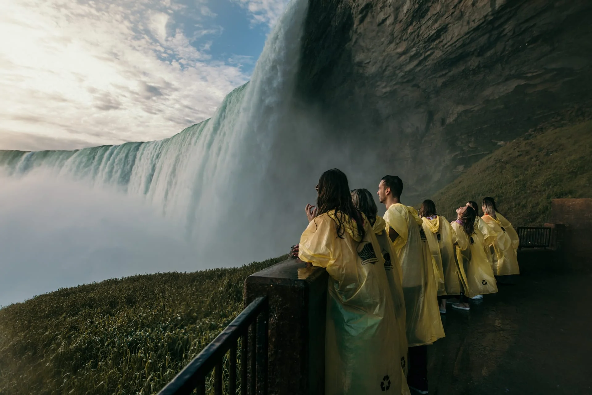 Tourists on lower observation deck viewing Horseshoe Falls with winter mist and ice