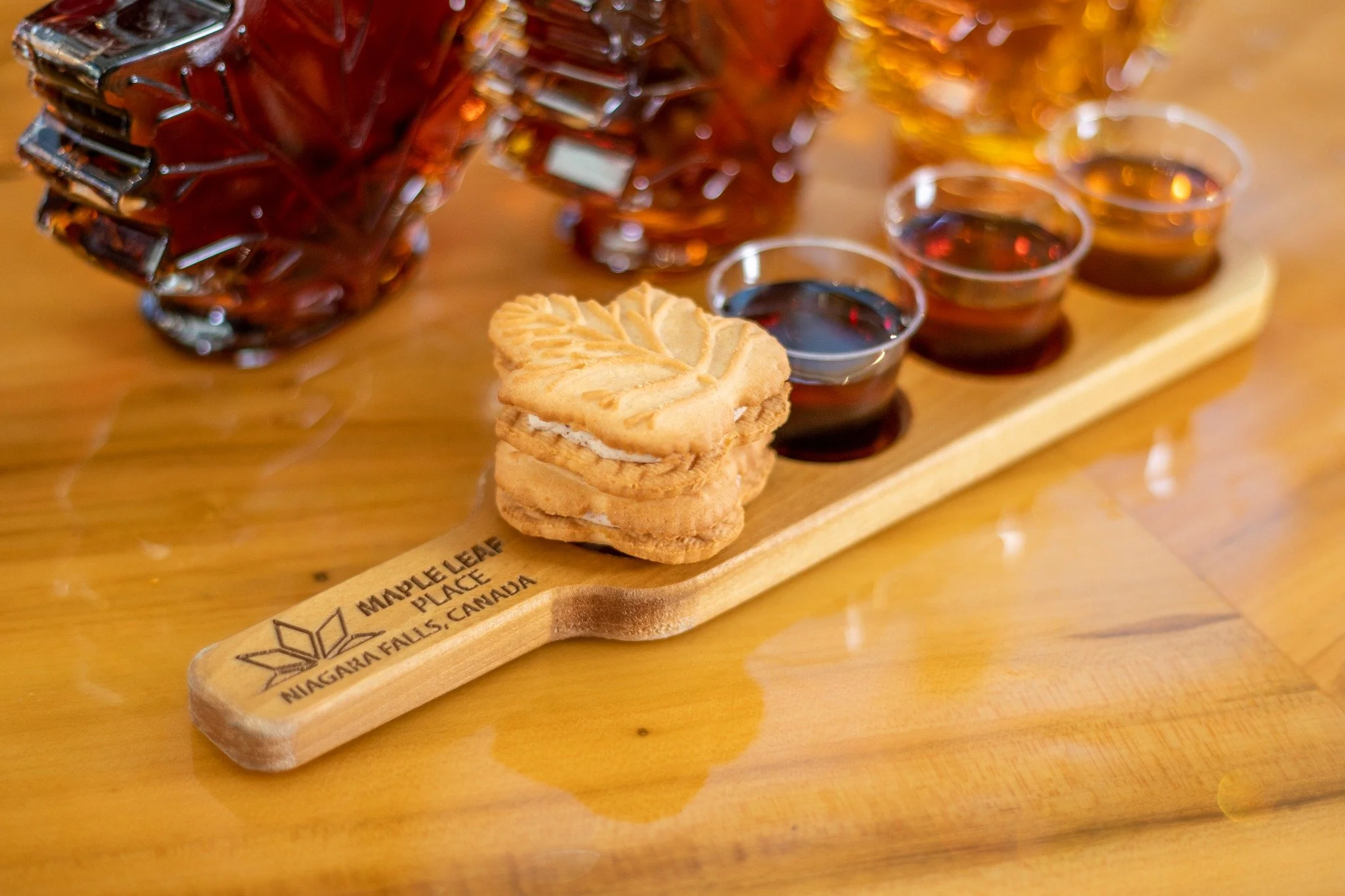 Maple syrup tasting display at Maple Leaf Place in Niagara featuring fresh samples and artisan products