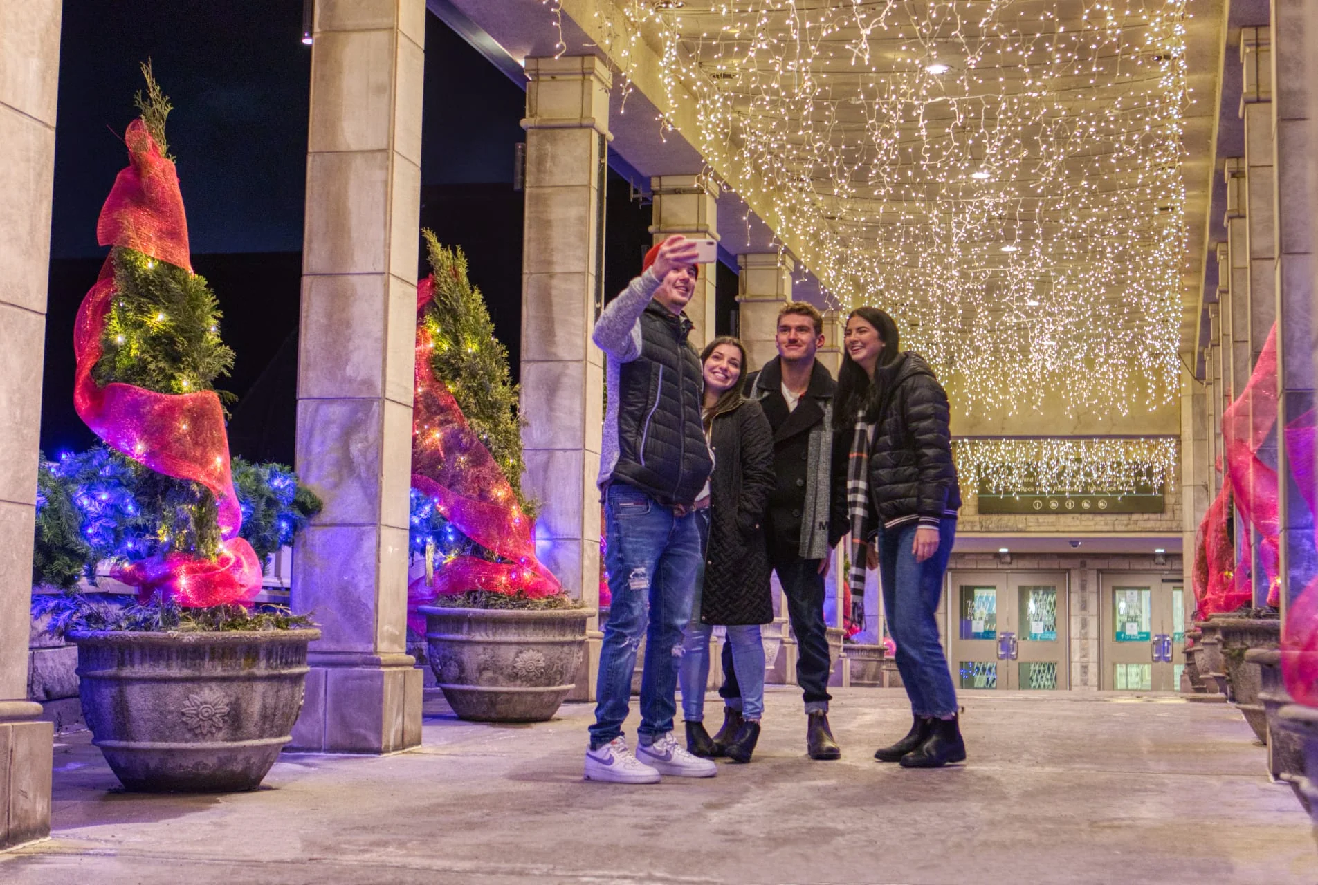 Group of friends enjoying the magical atmosphere at Niagara Winter Festival of Lights with festive illuminations