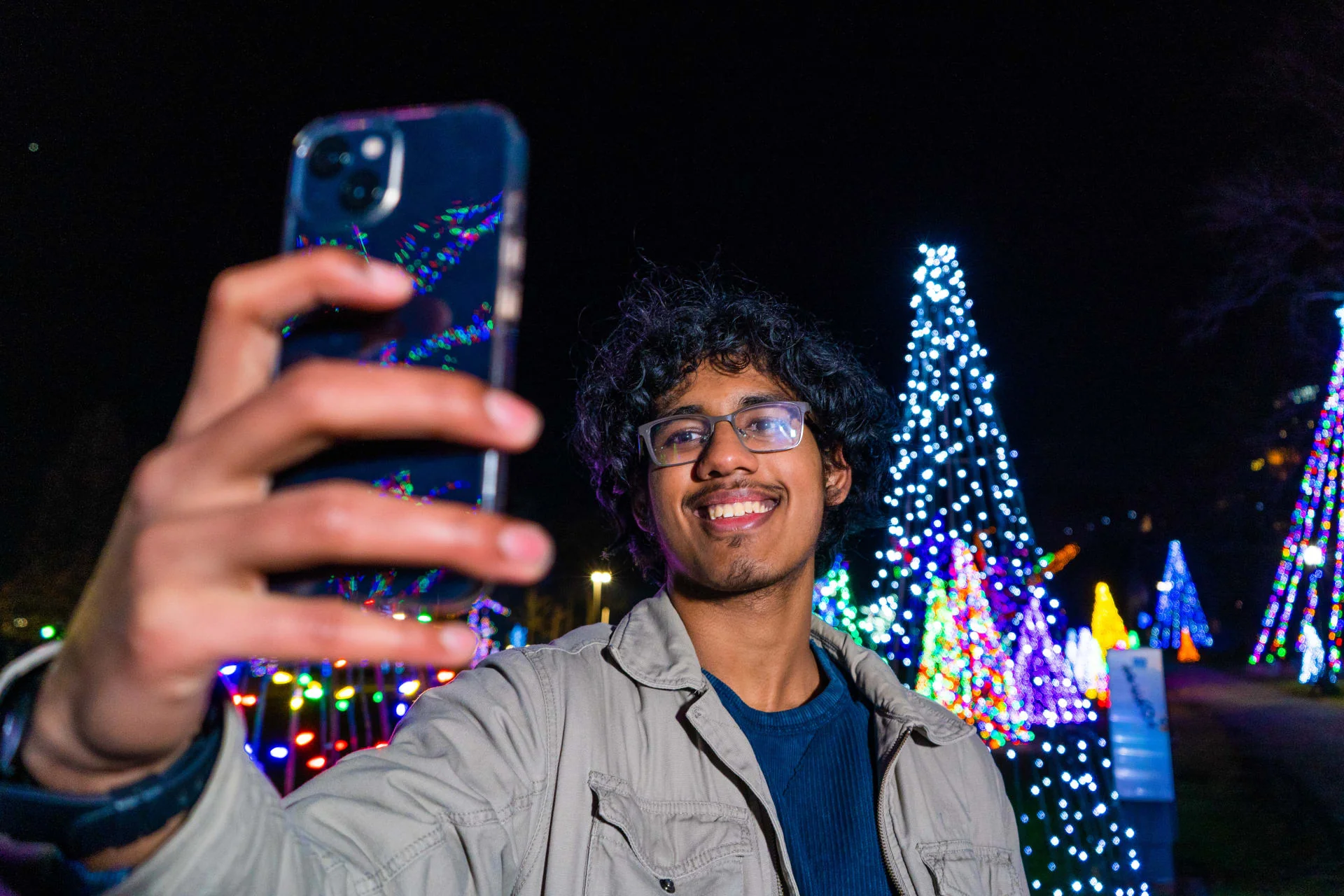 Visitors taking selfie at Niagara Winter Festival of Lights with festive light decorations